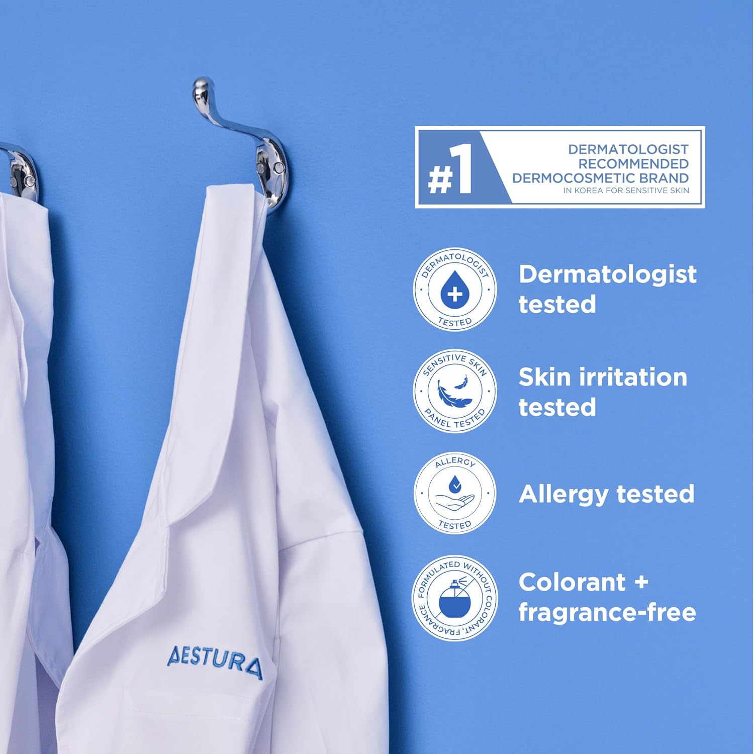 White AESTURA lab coats hanging on hooks featuring dermatologist-tested, skin irritation tested, allergy tested and colourant and fragrance free product information.