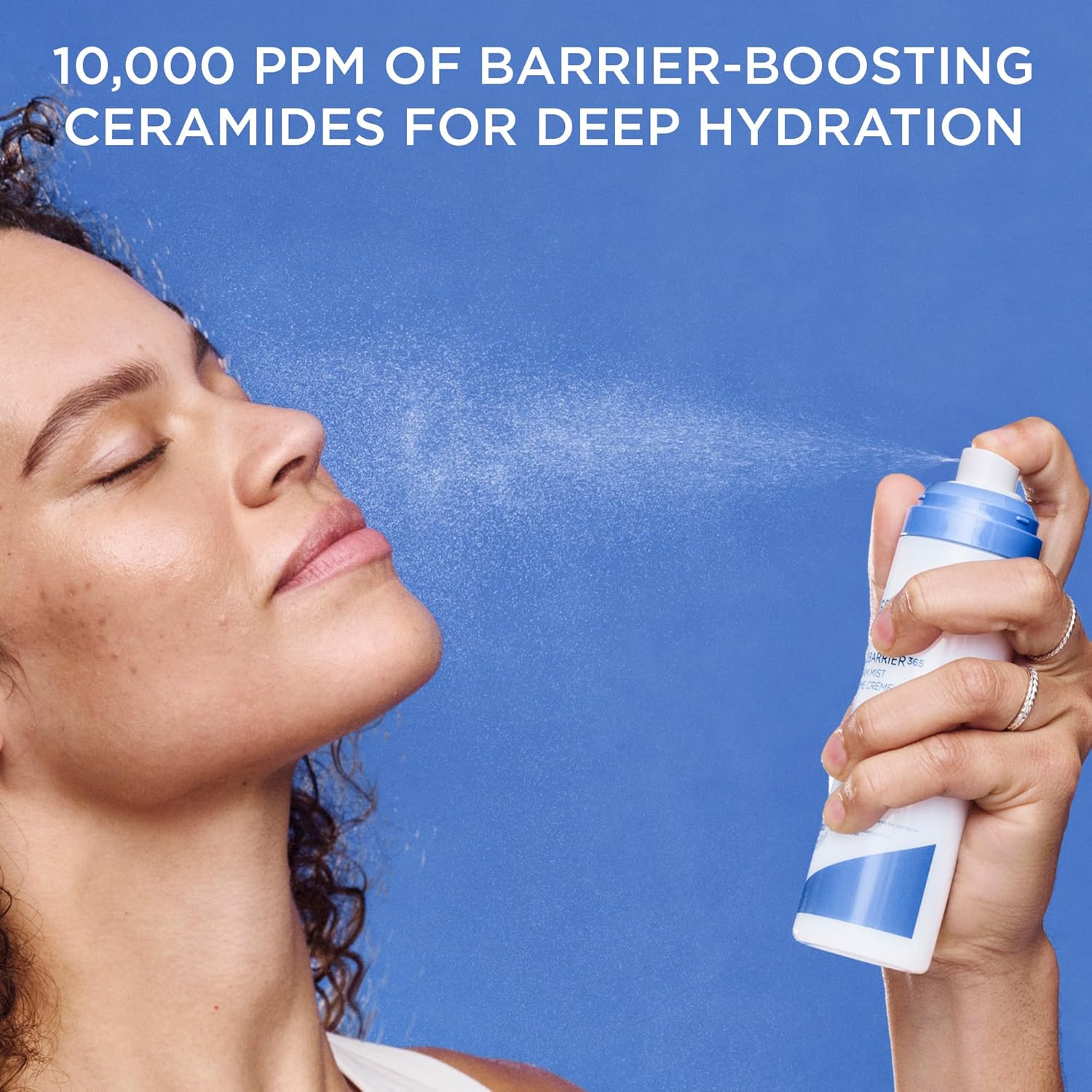 Woman applying AESTURA Atobarrier 365 Cream Mist with text about 10,000 ppm of barrier-boosting ceramides for deep hydration on a blue background