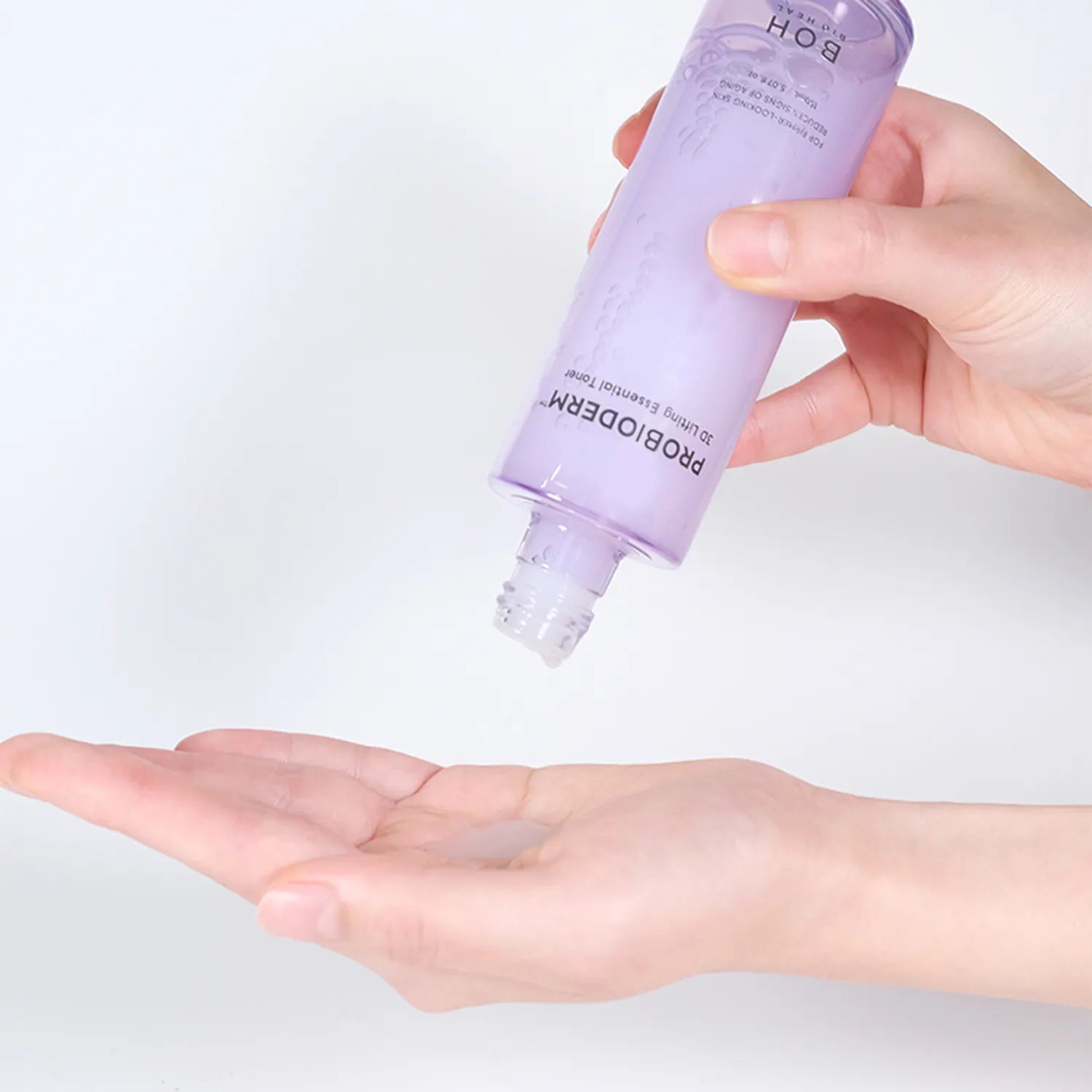 Hand holding a purple bottle labeled BIOHEAL BOH Probioderm 3D Lifting Essential Toner above an open palm on a light gray background