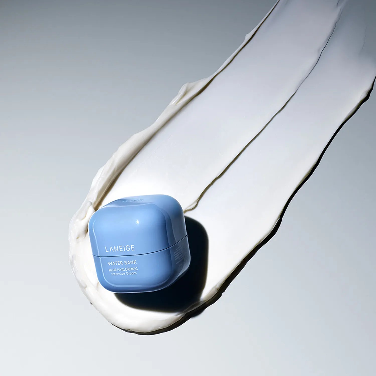 Blue LANEIGE Water Bank Blue Hyaluronic Intensive Cream container on a sample of the cream's consistency