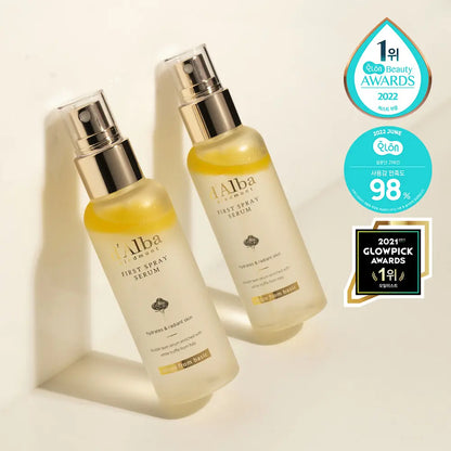 Two bottles of d'Alba White Truffle First Spray Serum with award badges from hwahae 2022 and glowpick 2021 on a beige background